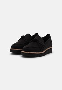 Scarpe slip-on nere in suede con design anteriore annodato e suola a zeppa con un accento testurizzato simile al sughero.