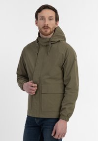 Olive green, hooded jacket with elastic cuffs and a front pocket. Material appears smooth and lightweight, suitable for outdoor wear.