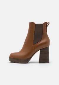 Brown faux leather ankle boot with a chunky heel, elastic side panels, and a pull tab. Smooth texture with a platform sole.