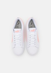 Sneaker bianchi con accenti rosa, materiale in pelle liscia, punta arrotondata e design classico con lacci. Presenta un logo sulla linguetta e sui lati.