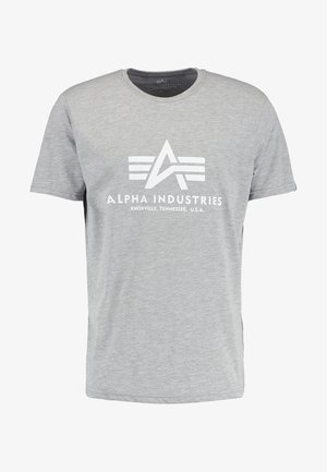 Siva bomba majica iz bombaža s kratkimi rokavi, ki ima na prsih velik beli grafičen logotip z besedilom "ALPHA INDUSTRIES" in obliko emblema.
