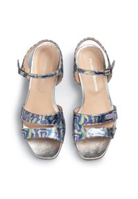 Völjandi sandaalit, joissa on monivärinen helmiäispintainen yläosa, hopeiset metallikoristeet ja pehmustettu beige sisäpohja. Mukana säädettävä nilkkahihna.