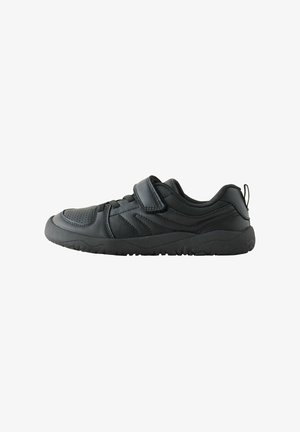 Czarny niski sneaker z rzepem, detalami sznurowadeł i wyściełanym kołnierzem na fakturowanej czarnej podeszwie, widziany od boku.