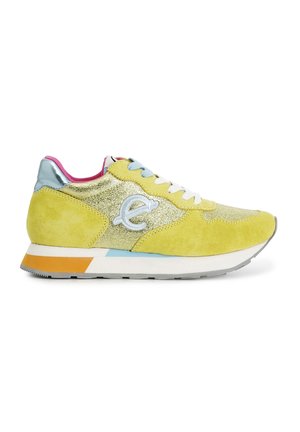 Gelbe Wildleder-Sneaker mit einem glitzernden goldenen Einsatz, metallic-silberner Ferse, weißen Schnürsenkeln und einer mehrfarbigen Sohle mit orangefarbenen und blauen Akzenten.
