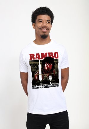 White short-sleeve T-shirt featuring a graphic print of a man with dark hair, text in red and black, and an aircraft illustration below.