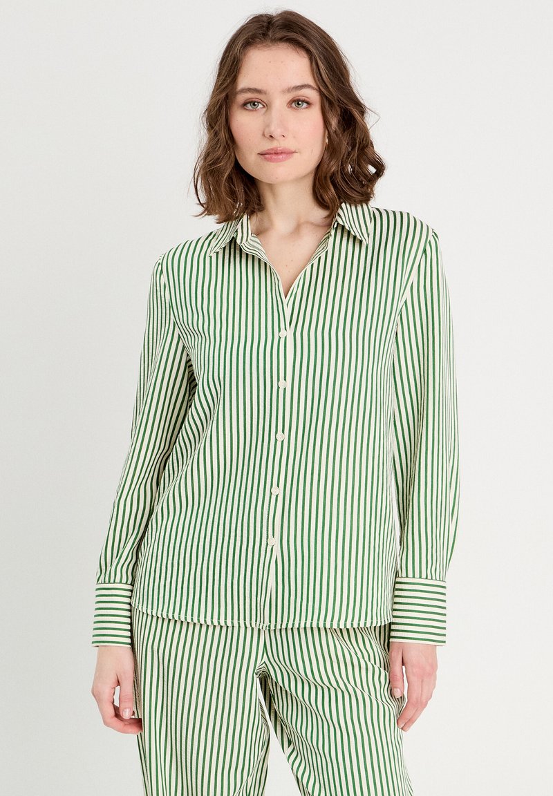 Chemise rayée verte et blanche à manches longues avec fermeture à boutons, col et manches à poignets, accompagnée d'un bas assorti. Texture de tissu douce.