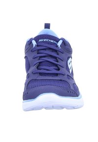 Zapatilla deportiva morada con parte superior de malla, punta redondeada y suela blanca. Presenta detalles azules y un diseño de cordones estándar.