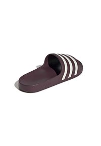 Une sandale slide Adidas violet foncé avec trois bandes blanches sur le dessus et le logo Adidas embossé sur le côté.