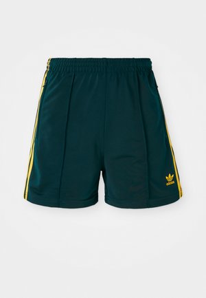 Shorts de sport vert foncé avec une taille élastique, dotés de rayures latérales jaunes et d'un logo jaune brodé sur le bas de la jambe.