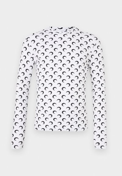 White long-sleeve fitted top covered in evenly spaced black crescent moon patterns against a plain background.