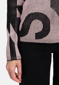 Gestreifter Pullover in Schwarz und Pink mit gewundenen Mustern. Der Stoff hat eine strukturierte Oberfläche, eine taillierte Silhouette und lange Ärmel.