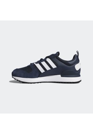 Granatowo-białe buty sportowe Adidas z siateczkowymi i zamszowymi detalami, trzema białymi paskami po bokach i fakturowaną czarną gumową podeszwą.