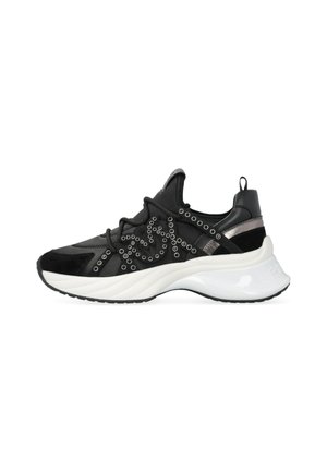 Baskets de sport noires avec des superpositions en daim et en maille, œillets décoratifs en argent, et une épaisse semelle blanche. Comprend une languette au niveau du talon.