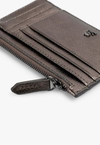 Tarjetero de bronce metálico con textura suave, múltiples ranuras para tarjetas y un compartimento con cremallera que incluye una lengüeta para tirar.