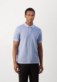 Polo de color azul claro en mezcla de algodón, con cuello clásico, tapeta de tres botones, mangas cortas y bordado del logo en el pecho.