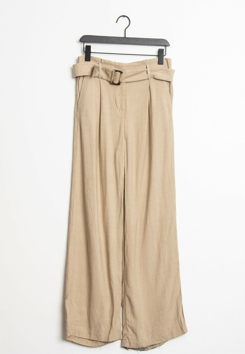 Pantalones de pierna ancha beige con cintura alta, que incluyen un cinturón de tela, pliegues y una textura ligera, colgando de una percha negra.
