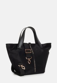 Borsa a tote nera in nylon con manici in pelle, elementi in metallo dorato e chiusura con zip. Presenta una tracolla rimovibile e dettagli col logo.