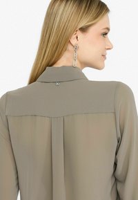 Blůza s dlouhým rukávem v taupe chiffon, s knoflíkovým zapínáním na krku a hladkou strukturou s rozděleným designem zadního yoku.