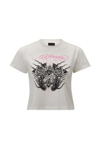 White cotton cropped t-shirt featuring a central black and pink graphic design of a heart, cross, and flames, with "Ed Hardy" text above.