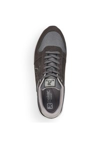 Mörkbrun sneaker med grå meshpaneler, rund tå och traditionell snörning. Har en vadderad sula och en ljusgrå yttersula.