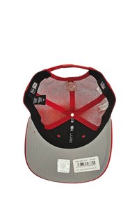 Rote Mütze mit grauem Schirm, Netz-Innenfutter und schwarzem Innenfutter. Verfügt über Etiketten und Markenkennzeichnungen, einschließlich eines Größenetiketts und eines Aufklebers auf der Innenseite.