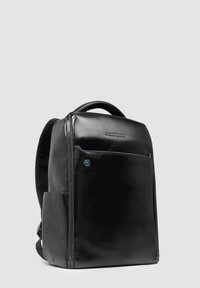 Mochila de cuero negro con una textura suave, que presenta un bolsillo frontal con cremallera, un acento azul y correas de hombro acolchadas para mayor comodidad.