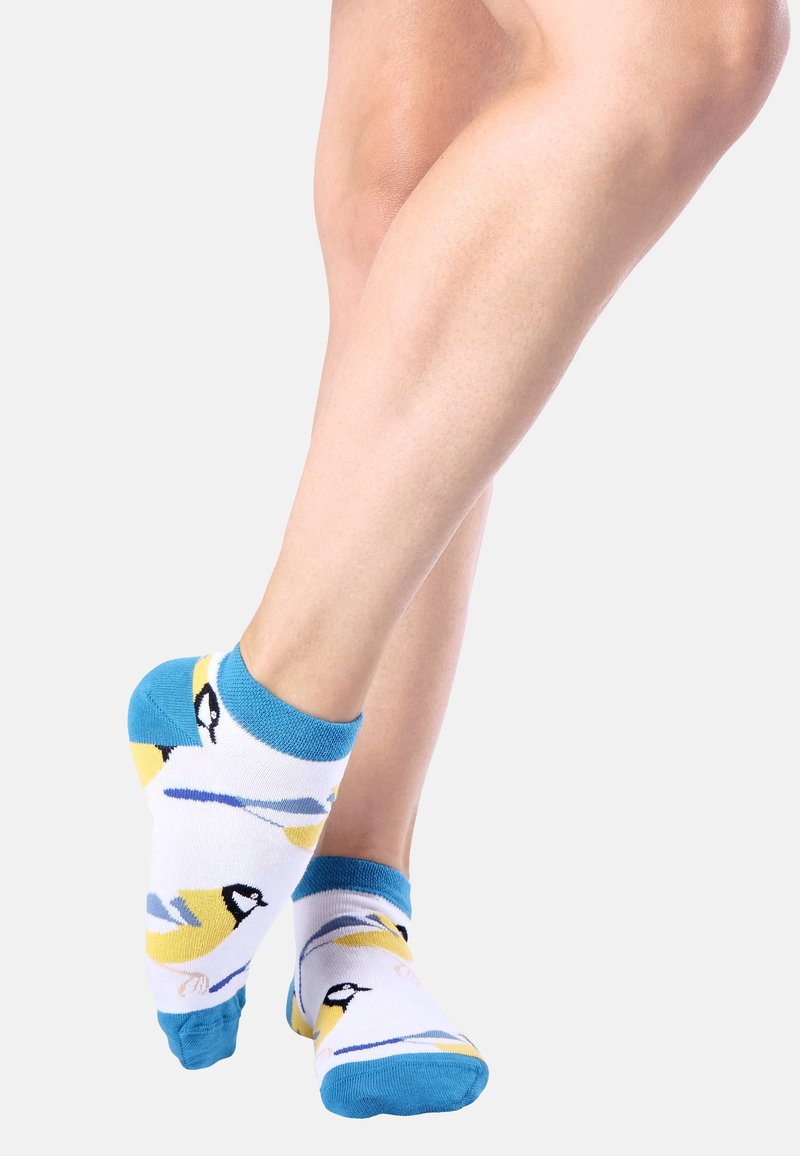 Weiße Knöchelsocken mit einem Muster aus blauen und gelben Vögeln, ergänzt durch türkisfarbene Akzente an Bündchen und Ferse sowie einer weichen, dehnbaren Stoffoptik.