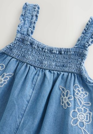 Robe en denim bleu avec des bretelles volantées, un corsage smocké et des motifs floraux brodés sur la jupe. Texture douce avec une sensation légère.