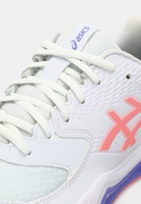 ASICS sportsko i hvit med lysegrå detaljer, rosa logo og teksturert overflate. Har polstret tunge og lisser for sikker passform.