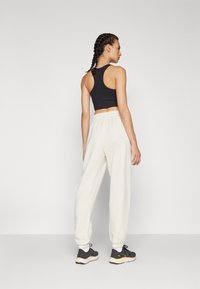 New Balance WARMING PERFORMANCE JOGGER - Jogginghose - offwhite
