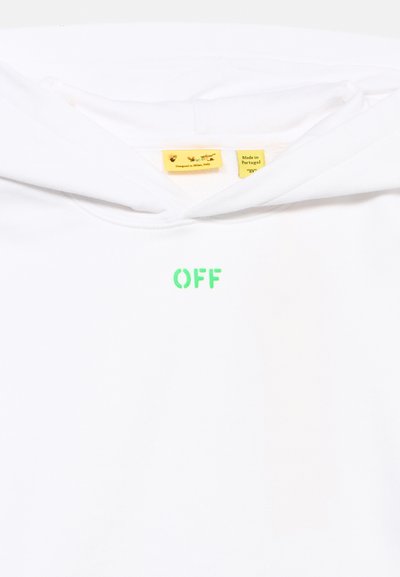Λευκό T-shirt με πράσινο κείμενο «OFF» τυπωμένο κάτω από τον γιακά και δύο κίτρινα ετικέτες που υποδεικνύουν ότι έχει σχεδιαστεί στο Μιλάνο και κατασκευαστεί στην Πορτογαλία.