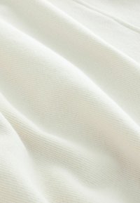 Tessuto bianco morbido e testurizzato con sottili strisce verticali, caratterizzato da una superficie liscia e da una leggera lucentezza. Ideale per abbigliamento o rivestimenti.