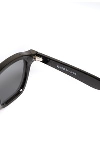 Mustad musta plastist päikeseprillid ruudukujuliste raamidega, hallide objektiividega ja metallise riistvaraga hingedel. Omab "BIG STAR" logo ja UV400 sildit.