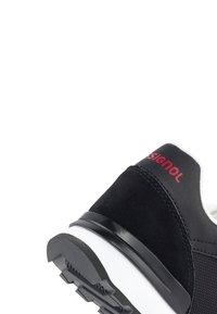 Zwarte sneaker met suède en mesh materialen, witte tussenzool, gestructureerde rubberen buitenzool en rode "SIGNOL" branding op de hiel.
