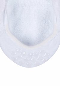 Chaussette blanche avec une texture en éponge douce, dotée d'un motif de grip en caoutchouc au fond et d'un bord de cheville lisse.