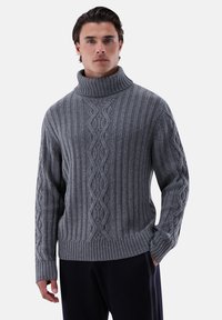 Grau gestrickter Pullover mit hohem geripptem Kragen, der strukturierte Muster und eine lockere Passform aufweist. Lange Ärmel mit Zopfmuster-Details.