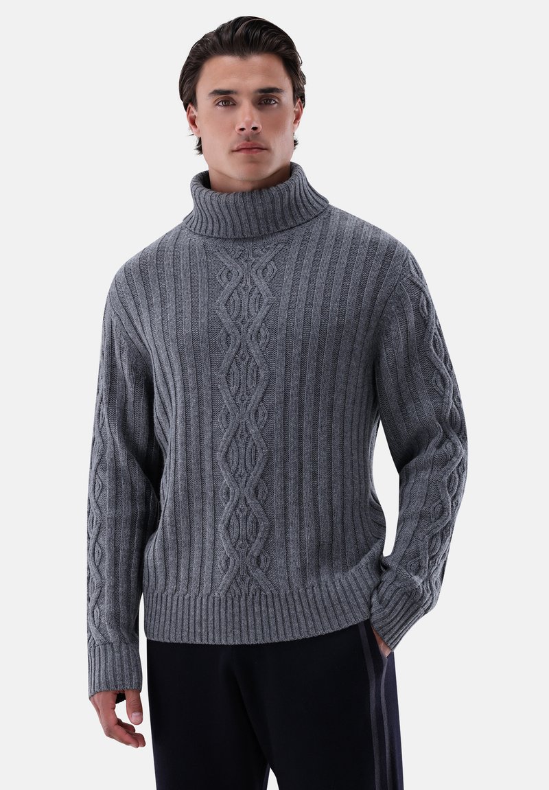 Grau gestrickter Pullover mit hohem geripptem Kragen, der strukturierte Muster und eine lockere Passform aufweist. Lange Ärmel mit Zopfmuster-Details.