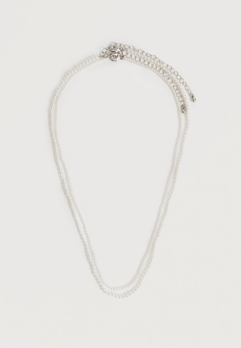 Κολιέ διπλής σειράς με πέρλες, ασημένια επέκταση αλυσίδας και κούμπωμα κρανίου σε λευκό φόντο.