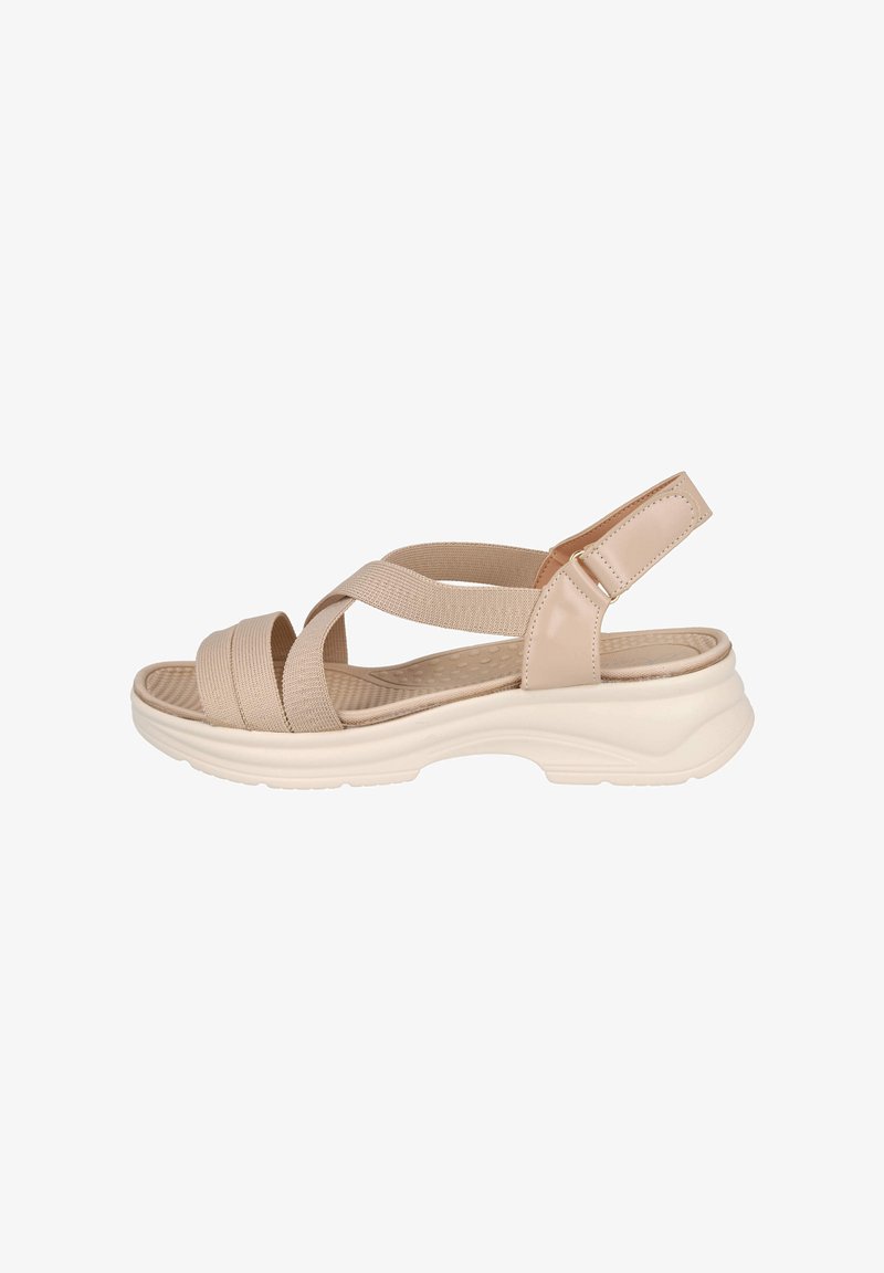 Sandalias beige con tiras cruzadas, material elástico, plantilla texturizada y suela acolchada. Correa trasera con detalle de hebilla.