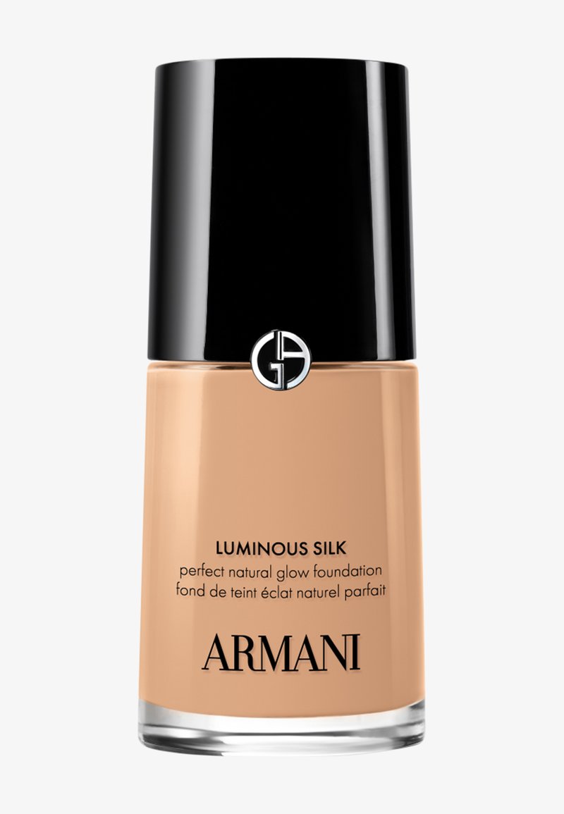 Bottiglia di vetro del fondotinta Armani Luminous Silk con tappo nero e logo, fondotinta liquido beige all’interno.