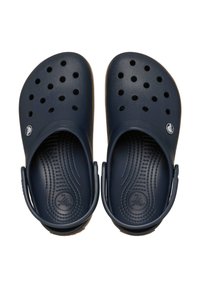 Zuecos azul oscuro con orificios de ventilación, suelas texturizadas y correas ajustables en el talón. Fabricados con plástico duradero y acabado suave.