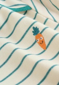 Vaalea kerrosripsinen kangas, jossa on teal-väriset vaakasuorat raidat ja pieni oranssi brodeerattu porkkana, jolla on hymyilevä naama. Sileä rakenne, leikkisä muotoilu.