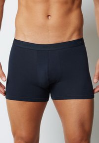 Boxeri pentru bărba�ți, de culoare albastru închis, dintr-un material moale, cu un elastic confortabil la talie, pe care se află un logo embossat, și cu un design ajustat.