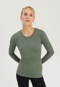 Rippstrickpullover mit langen Ärmeln in einem gedämpften Grünton, mit Rundhalsausschnitt und figurbetonter Silhouette, aus strukturiertem Strickstoff gefertigt.