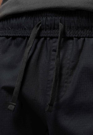 Sorte atletiske shorts i et struktureret og let materiale. Har en elastisk linning med snorejustering og sidelommer.