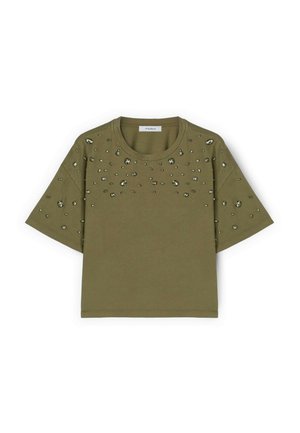 Haut vert olive à manches courtes avec encolure ronde, orné de petits et moyens clous métalliques irréguliers dispersés sur la poitrine et les manches.