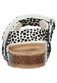 Zwart-witte sandaaltjes met stippen, voorzien van kurken binnenzolen, een verstelbare enkelband en een rubberen zool zichtbaar vanuit de achteraanzicht.