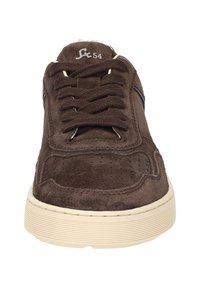 Sneakers en daim marron avec bout rond, semelle en caoutchouc beige, lacets plats et détail de rayure sur le côté. Surface texturée avec perforations. Logo du modèle sur la languette.