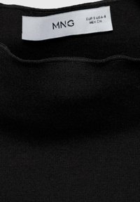 Tessuto nero con una finitura testurizzata, caratterizzato da un'etichetta che riporta "MNG" e dettagli delle dimensioni in testo bianco. Design con bordo ondulato.