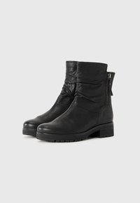 Svarta läderankelboots med en slouchad design, sidodragkedja, texturerad yta och kraftig klack. Grov sula för bättre grepp.
